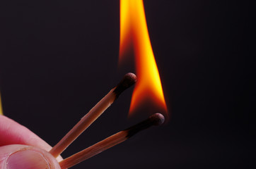 Two lit matches. Close-up on a black background.