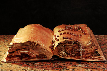 Old bible and crucifix on black background