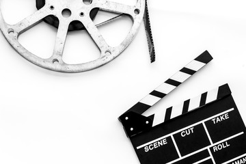Filmings concept. Clapperboard and film stock on white background top view space for text