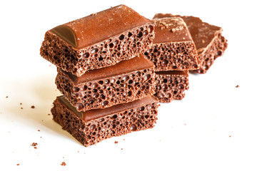 Delicious dark porous chocolate isolated on a white background close up