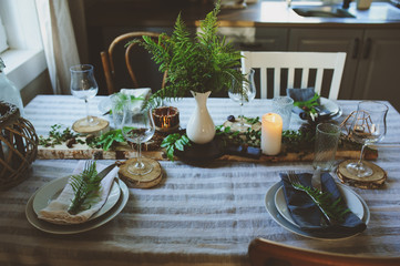 cozy evening family dinner in rustic style. Table summer setting in natural style with wild ferns in wooden cottage or country house.