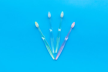 Oral hygiene. Plastic toothbrushes on blue background top view space for text