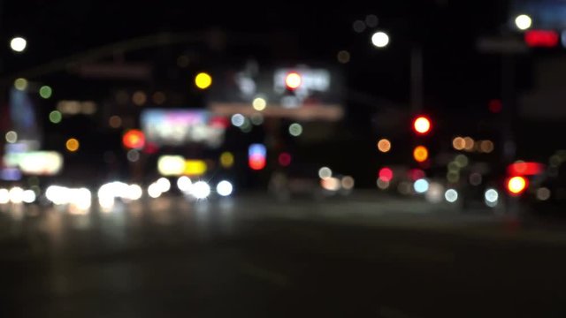 Blurred traffic lights coming more into focus on a city street