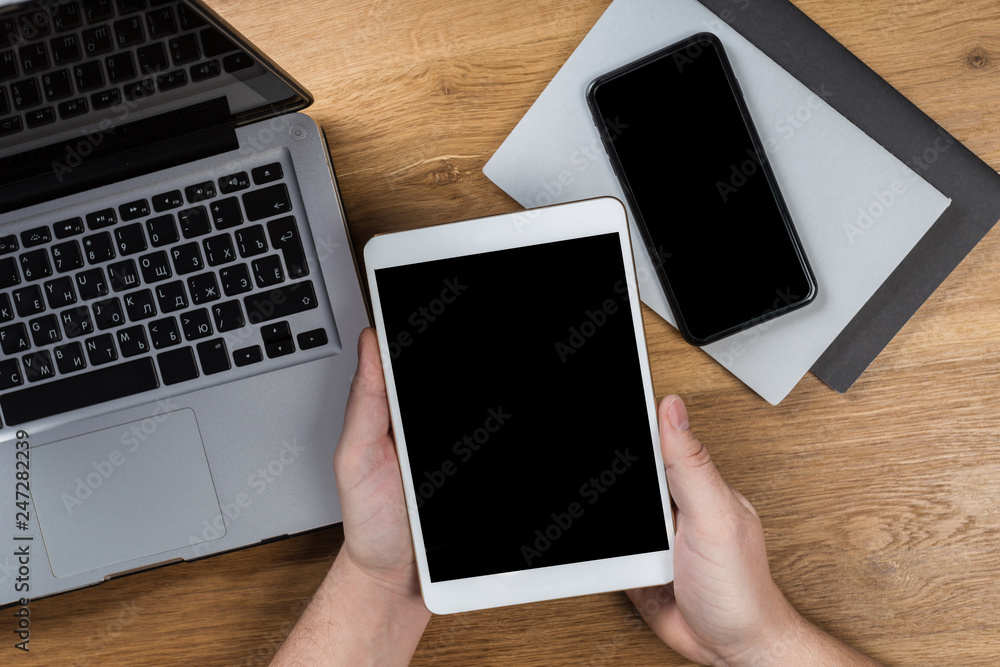 Wall mural man works using digital devices. above view of desktop workspace.