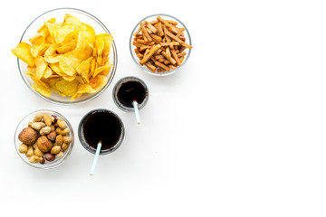 Snacks for TV watching. Chips, nuts, soda, rusks on white background top view space for text