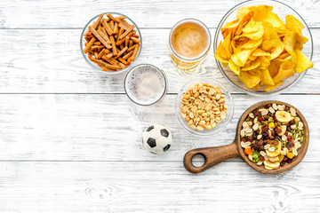 Snacks for watching football on TV. Watching sports. Chips, nuts, rusks near beer and soccer ball...