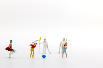 Miniature people: Golfers hit golf balls forward. Target and growth in business concept.