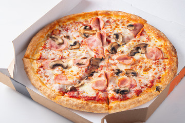 Italian fast food. Delicious hot pizza in a box with ham, champignons sliced and served on white...