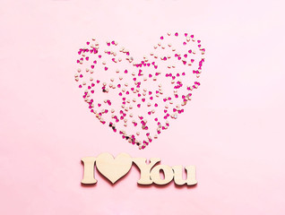 Festive pink background with spangles in the shape of heart. Concept Valentines Day or Mothers Day.
