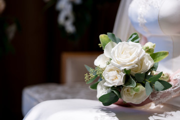 Bride holds a wedding bouquet. Very nice young woman in a white wedding dress holding a beautiful blossoming flower bouquet of various kinds of fresh real flowers, in pink, red and pastel cream color