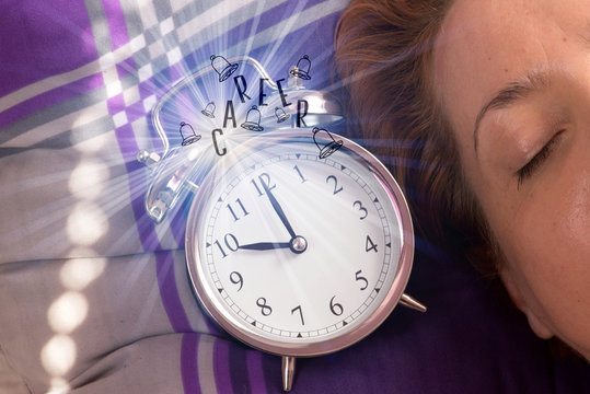 Eine junge Frau im Bett, ein Wecker und Aufruf zur Karriere