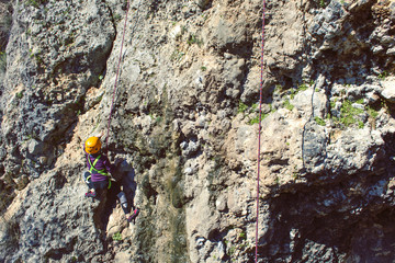 Guy climbing in Greece and beautiful forest and cliff landscape on the background