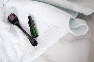 Dermaroller, Handtuch und grüne Beauty Serum Flasche zum  Microneedling für Anti Aging Lifting...