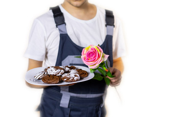 builder with a rose in their hands and cookies congratulates women or men on the holiday. March 8, International Women's Day, Valentine's Day, new year, anniversary, birthday, holiday. isolated. Blur