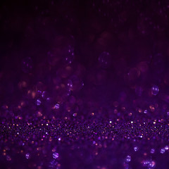 Purple glitter magic background. Defocused light and free focused place for your design.