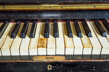 Fototapeta na wymiar Old vintage wooden carved piano in dark room, keyboard detail