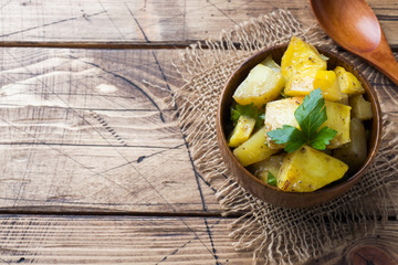 Baked potatoes with spices and herbs in wooden plate. Copy space