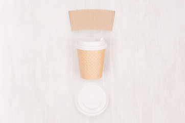 Ribbed coffee kraft paper cup with blank label, cap on light wood board, top view. Mockup for branding identity, advertising and design concept.