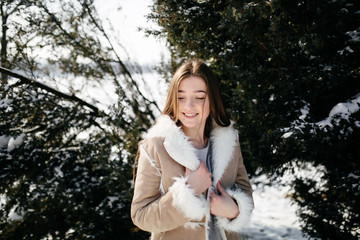 Fototapeta na wymiar Young Beautiful girl Smiling and posing Outdoors in Snowy Winter