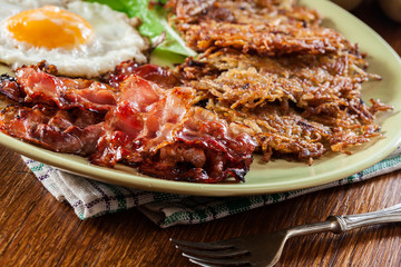 Hash browns. Potato pancakes with crispy fried bacon and fried egg