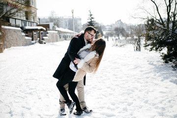 Fototapeta na wymiar Young Beautiful Couple Taking Fun and Smiling Outdoors in Snowy Winter