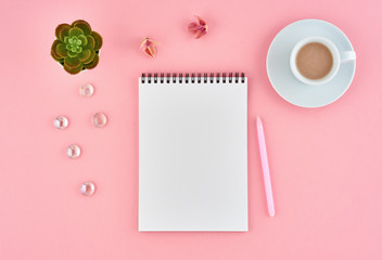 Blank notepad white page and cup of cocoa on pink desk, color background. Top view,  flat lay