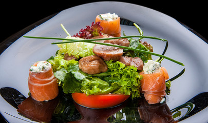 Salad with salmon and chestnuts on a black background