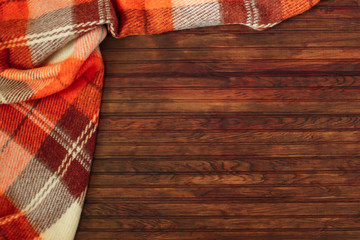 Orange plaid in a cage on a wooden autumn background. Autumn concept. Autumn Time