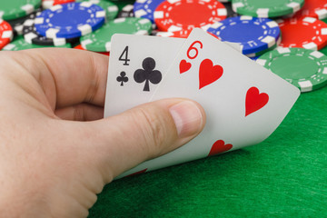 Hand with playing cards in casino