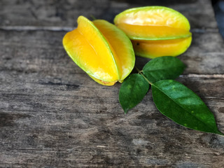 Star Apple and green leaf on the vintage wooden table with natural light. Star fruit. Sweet and sour taste. Healthy and diet fruit. 