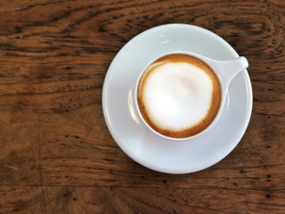 Cappuccino coffee  in white cup  on the wooden table. Relaxing and fulfill energy. Copy space