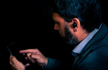 Man using smartphone and bluetooth headphones