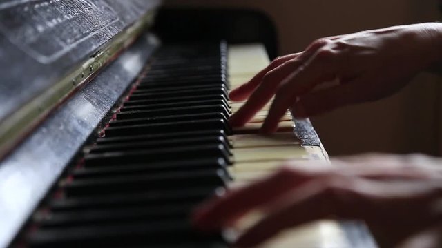 Close up fingers of woman pianist at the rusty piano keys, arms plays solo of music. Hands of female musician playing. Music instrument, solo pianist, song composer, hobby, practice study.