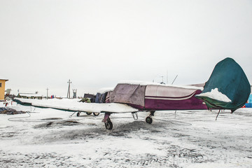 A small plane stands in a case protecting it from precipitation at the airport at the airport in the winter © oksanamedvedeva
