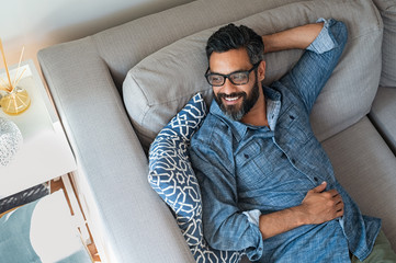 Mixed race man relaxing on couch