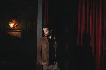 Young bearded male doing fashion shooting in vintage bar. 