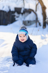 Fototapeta na wymiar baby boy sitting on snow