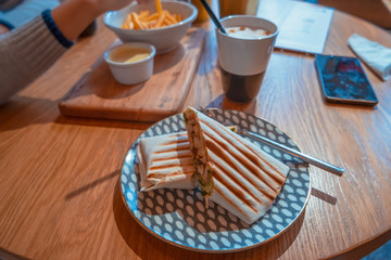 Mexican fast food wrapped burritos with chicken and vegetables closeup at plate on table