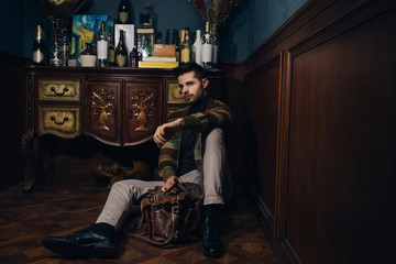 Young bearded male doing fashion shooting in vintage bar. 