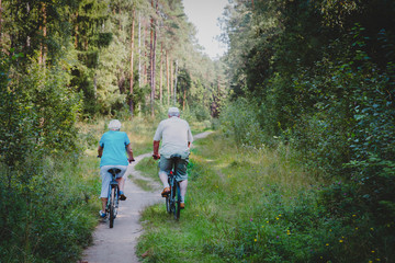 Naklejka premium active senior couple riding bikes in nature