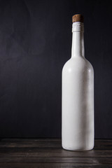 Wine white bottle stands on a wooden table