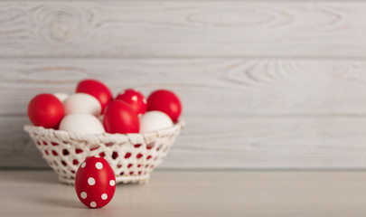 Happy Easter! Painted Easter eggs - red, white and red with white polka dots on a gray wooden background.