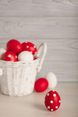 Happy Easter! Painted Easter eggs - red, white and red with white polka dots on a gray wooden background.