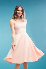 Fototapeta na wymiar attractive slim woman dancing in studio in pink dress