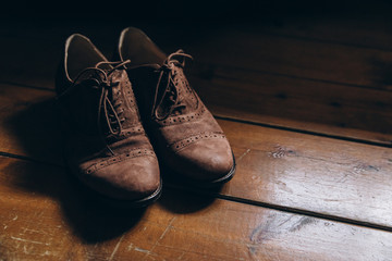 brown handmade men's shoes are in a room on a vintage wooden floor
