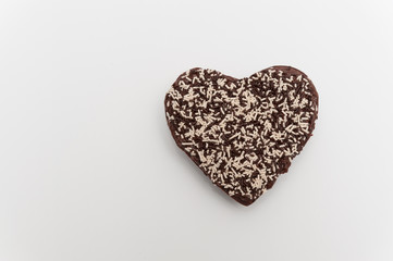 Chocolate heart-shaped topping with granulated chocolate. Celebration for Valentine's Day or Mother's Day. Isolated on white background. Top view. Space for text on the left.