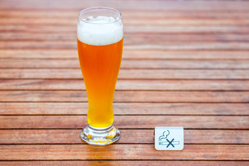 Glass of light beer on the wooden table.