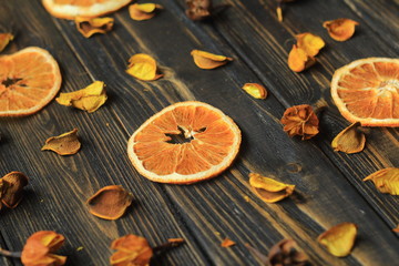 sliced orange and hibiscus petals on wooden background