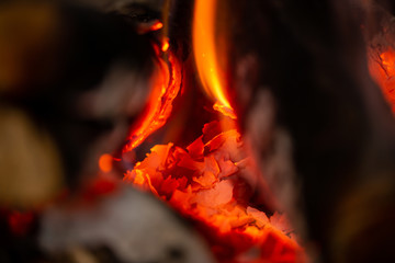 A fire is burning in the fireplace, slowly coal is being produced