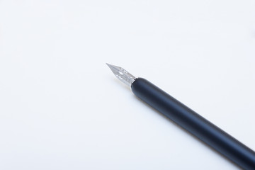 Schwarzer Federhalter mit Feder für Kalligrafie und Schreiben auf dem weißen Blatt-2
